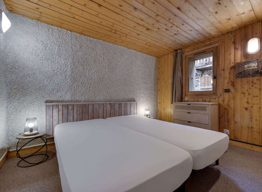 This cozy bedroom features a rustic design with wooden accents and a textured wall.