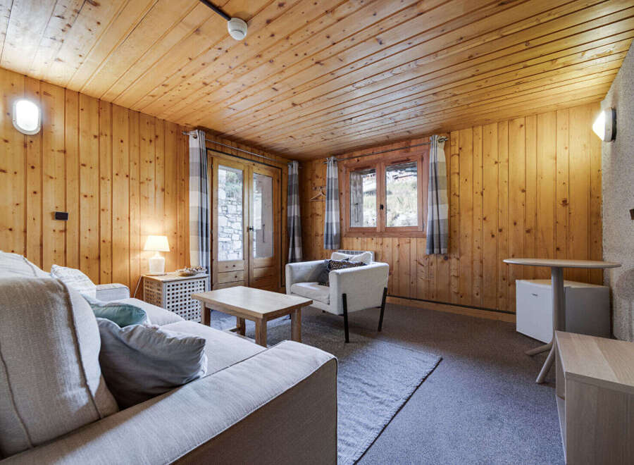Step into this cozy cabin retreat, featuring warm wood paneling and a welcoming atmosphere.