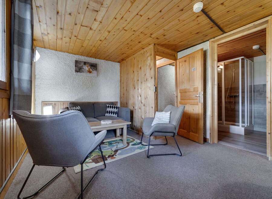 Discover the charm of this cozy property, featuring a comfortable living area with stylish gray chairs and a sofa.