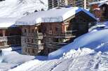 Discover the charm of this stunning wooden chalet nestled in a snowy mountain landscape.