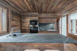 This stunning kitchen showcases a rustic design with wood paneling and a sleek countertop.