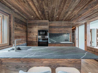 This stunning kitchen showcases a rustic design with wood paneling and a sleek countertop.