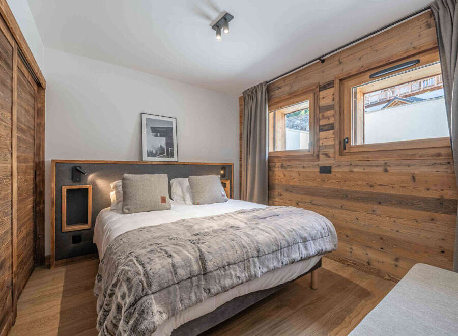 This cozy bedroom features a comfortable bed with a plush, faux fur blanket, perfect for a relaxing retreat.