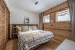 This cozy bedroom features a comfortable bed with a plush, faux fur blanket, perfect for a relaxing retreat.