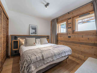 This cozy bedroom features a comfortable bed with a plush, faux fur blanket, perfect for a relaxing retreat.