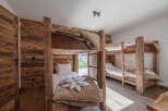 This cozy bedroom features rustic wooden bunk beds, perfect for a family or group getaway.