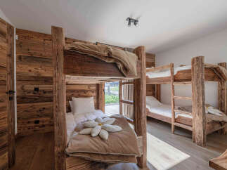 This cozy bedroom features rustic wooden bunk beds, perfect for a family or group getaway.