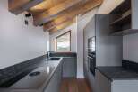 This modern kitchen boasts a sleek design with its gray cabinetry and countertops.