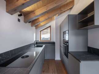 This modern kitchen boasts a sleek design with its gray cabinetry and countertops.