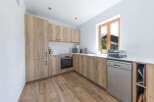 This modern kitchen boasts sleek wooden cabinetry and a bright, airy feel.