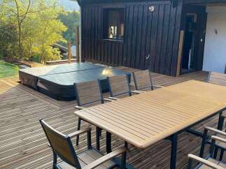 Enjoy luxurious outdoor living with this stunning property featuring a hot tub and a spacious deck.