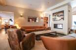 Experience luxury living in this stunning property, featuring a cozy living room with a fireplace and stylish seating.