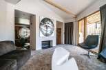 Step into luxury with this stunning property, featuring a cozy fireplace and a modern, white chair.