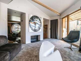 Step into luxury with this stunning property, featuring a cozy fireplace and a modern, white chair.