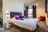 Experience luxury in this stunning bedroom featuring a plush king-size bed with vibrant purple accents.