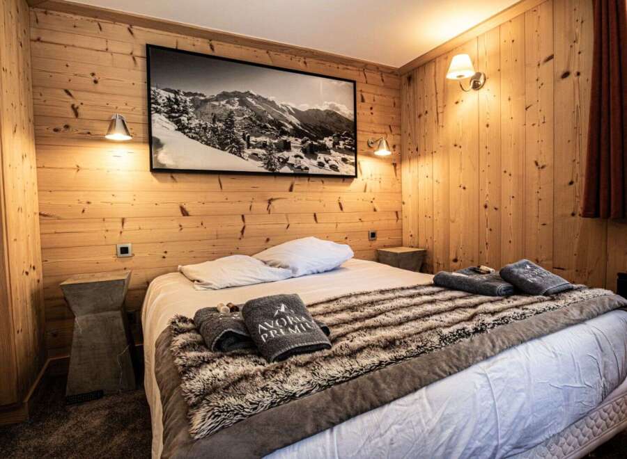 This cozy bedroom features a rustic wooden wall design, creating a warm and inviting atmosphere.