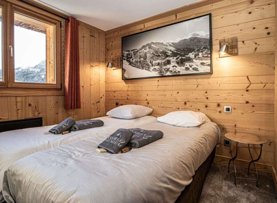 Experience the cozy charm of this bedroom, featuring warm wooden paneling and a stunning mountain view.