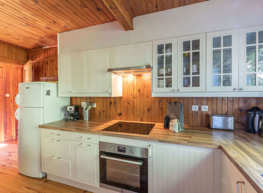 This charming kitchen boasts a warm and inviting atmosphere with its wooden accents and ample natural light.