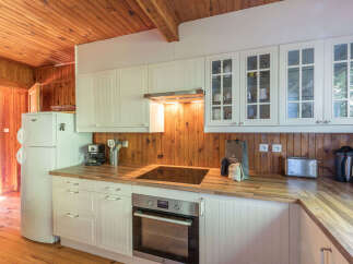 This charming kitchen boasts a warm and inviting atmosphere with its wooden accents and ample natural light.