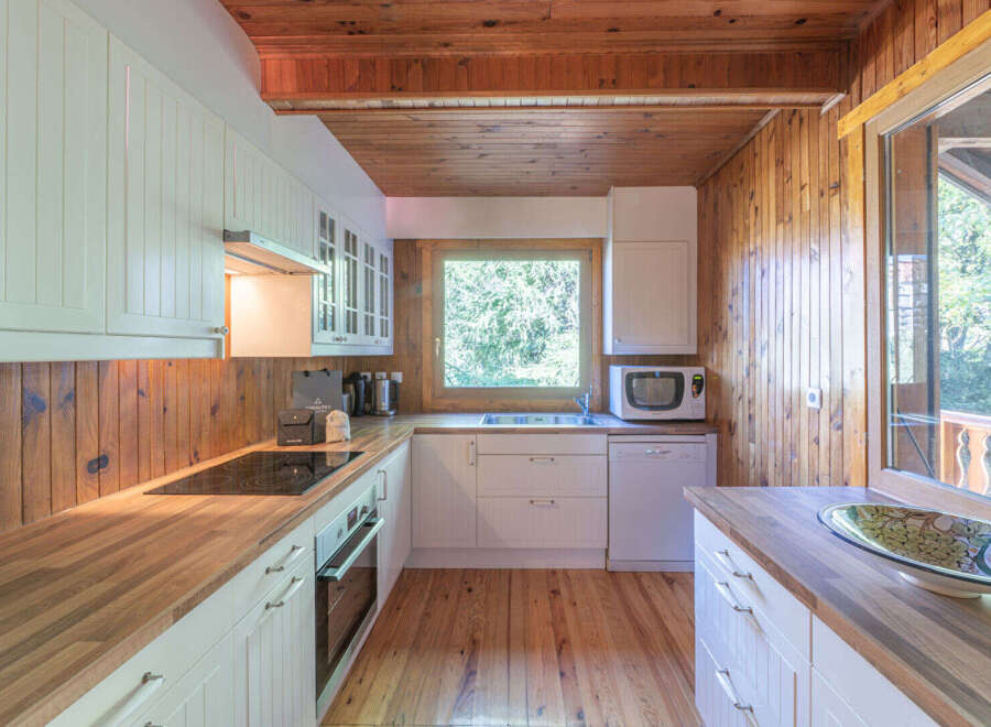 This charming kitchen boasts a warm, inviting atmosphere with its wooden accents and ample natural light.