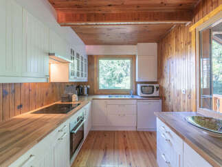 This charming kitchen boasts a warm, inviting atmosphere with its wooden accents and ample natural light.