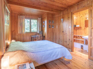 This charming bedroom features warm wooden paneling and a cozy atmosphere, perfect for a relaxing retreat.