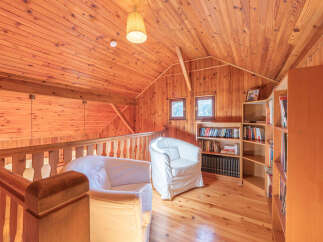 This cozy attic space features a warm, inviting atmosphere with its wooden walls, ceiling, and flooring.