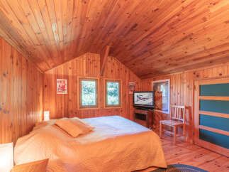 This cozy bedroom features beautiful wood paneling throughout, creating a warm and inviting atmosphere.