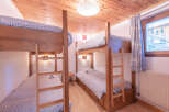This cozy bedroom features two sets of bunk beds, perfect for accommodating multiple guests or family members.