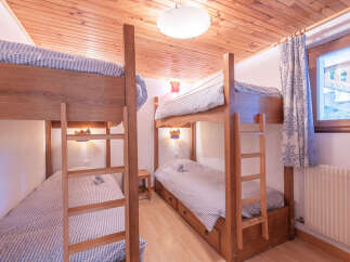 This cozy bedroom features two sets of bunk beds, perfect for accommodating multiple guests or family members.
