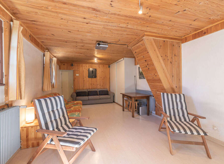 Step into this cozy living space, featuring a warm wooden interior and inviting atmosphere.