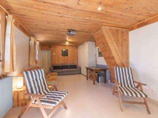 Step into this cozy living space, featuring a warm wooden interior and inviting atmosphere.