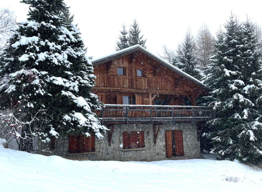 Nestled amidst a snowy landscape, this charming wooden chalet offers a cozy retreat.