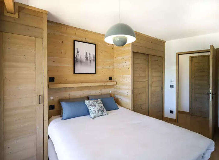 This cozy bedroom features beautiful wooden paneling, creating a warm and inviting atmosphere.
