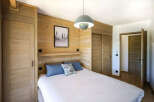 This cozy bedroom features beautiful wooden paneling, creating a warm and inviting atmosphere.