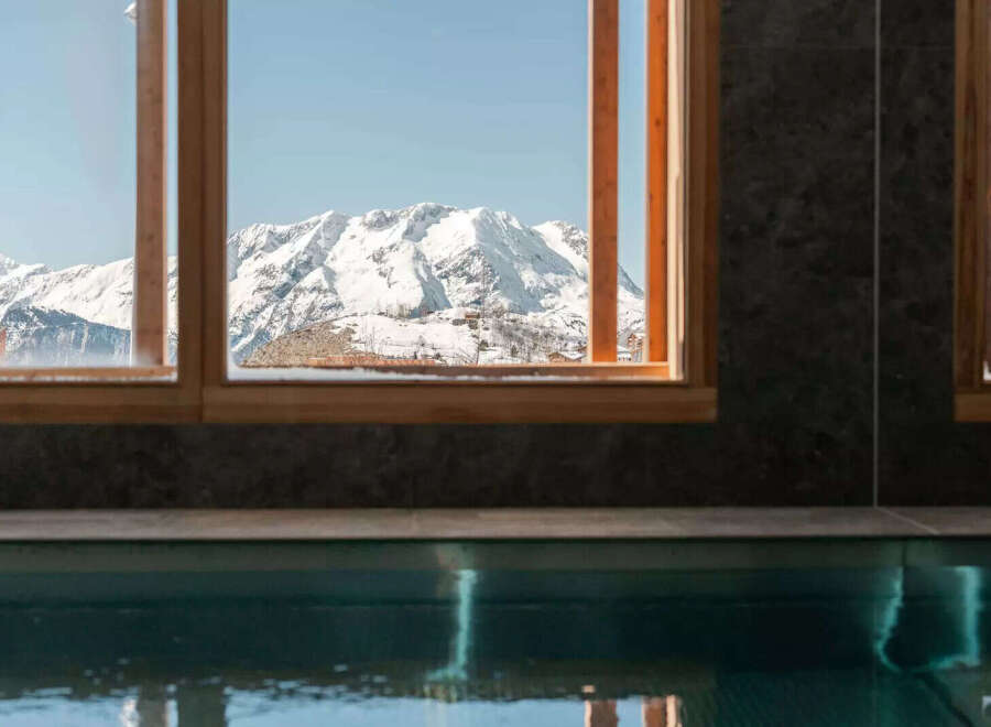 Experience the ultimate in luxury with this stunning property featuring breathtaking mountain views framed by elegant windows.