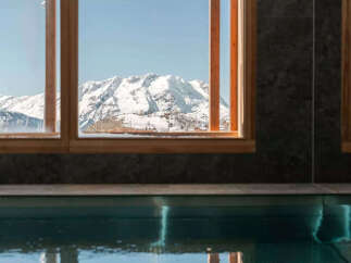 Experience the ultimate in luxury with this stunning property featuring breathtaking mountain views framed by elegant windows.