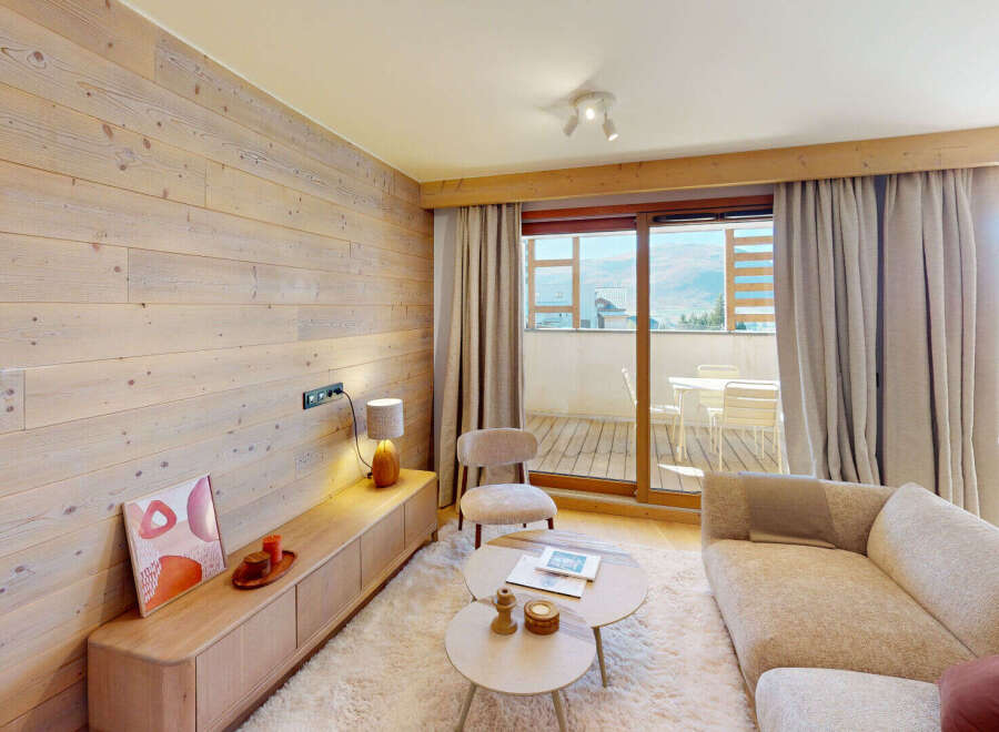 Experience modern alpine living in this beautifully appointed living room, featuring a warm, wood-paneled accent wall and a plush, textured rug.