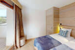 Experience cozy mountain living in this charming bedroom featuring two twin beds adorned with plush blue and plaid bedding.