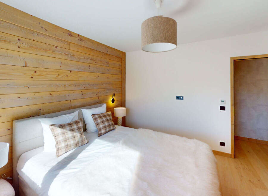 Experience rustic charm in this inviting bedroom, featuring a striking wooden accent wall that adds warmth and character.