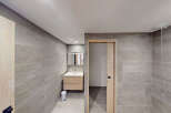 Experience modern comfort in this beautifully appointed bathroom, featuring sleek grey tiled walls and a floating wooden vanity with a clean white sink.
