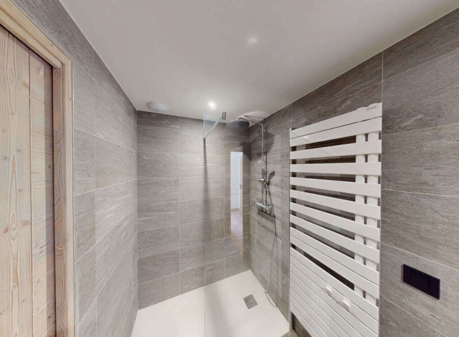 Experience modern luxury in this stunning bathroom, featuring a spacious walk-in shower with sleek glass enclosure and a stylish white heated towel rack.