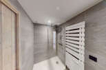 Experience modern luxury in this stunning bathroom, featuring a spacious walk-in shower with sleek glass enclosure and a stylish white heated towel rack.