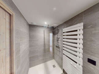 Experience modern luxury in this stunning bathroom, featuring a spacious walk-in shower with sleek glass enclosure and a stylish white heated towel rack.