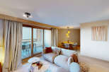 Experience modern living in this spacious apartment, featuring a comfortable living area with plush seating and a stylish dining space perfect for entertaining.