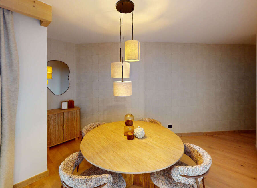 Experience elegant dining in this beautifully appointed space, featuring a round wooden table perfect for intimate gatherings.