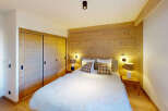 Experience cozy mountain living in this charming bedroom featuring a plush white duvet and warm wooden accents.
