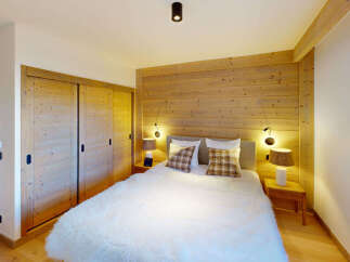 Experience cozy mountain living in this charming bedroom featuring a plush white duvet and warm wooden accents.