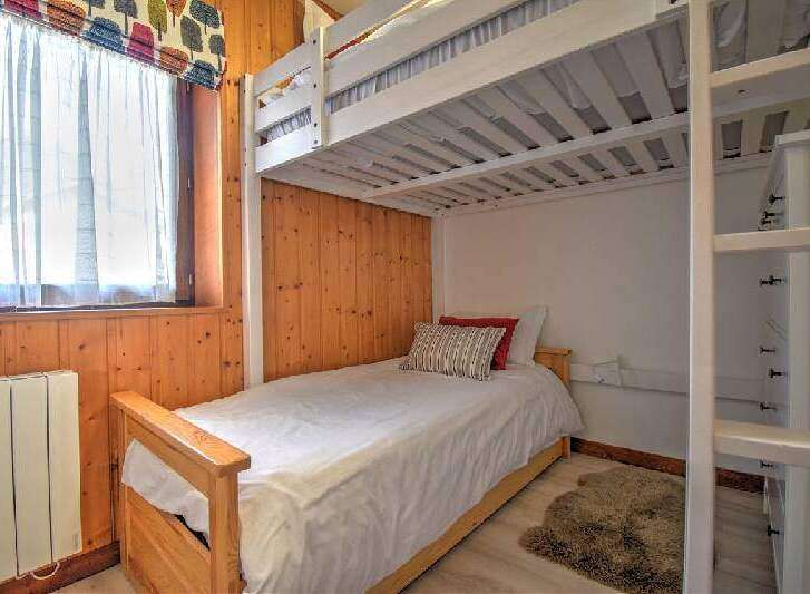This cozy bedroom features a bunk bed, perfect for accommodating guests or family members.