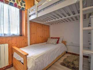 This cozy bedroom features a bunk bed, perfect for accommodating guests or family members.